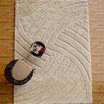 Large white shaggy area rug with a carved geometric line pattern and plush high pile.