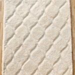 A plush White Rectangle Shaggy Rug featuring a carved diamond pattern and a dense pile on a wooden floor.