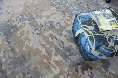 Anchor the Room with a Rug – Pouf and Magazine Styling Pouf on rug with magazine adding style and function to living room decor