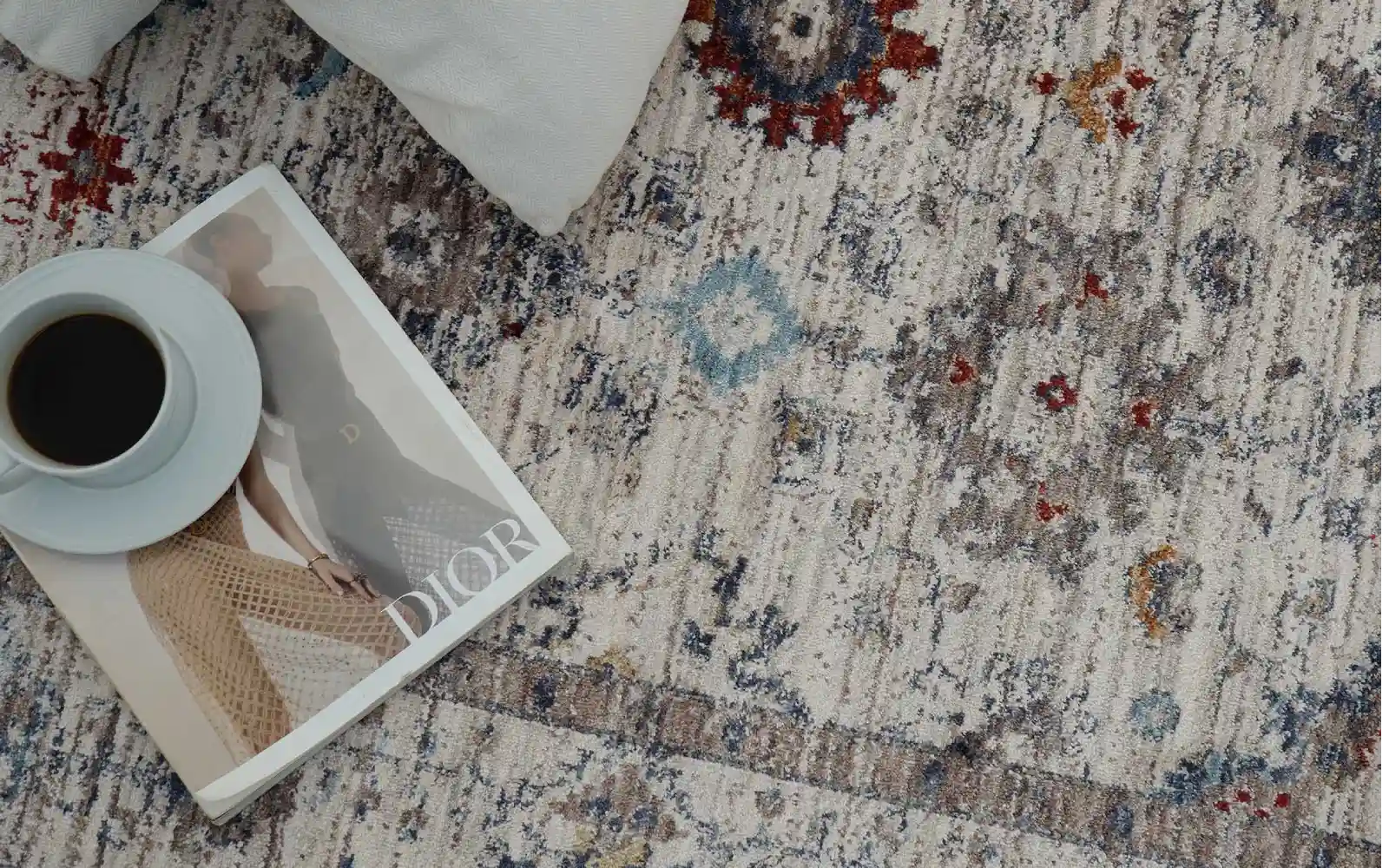 Beautifully designed living room featuring a hand-knotted patterned carpet, vibrant cushions, and a mix of geometric and floral motifs enhancing home design.