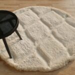 A plush White Round Shaggy Rug featuring a carved checkered pattern and a high pile.