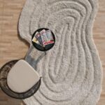 Beige and white wavy texture shape rug with concentric 3D patterns and irregular organic borders.