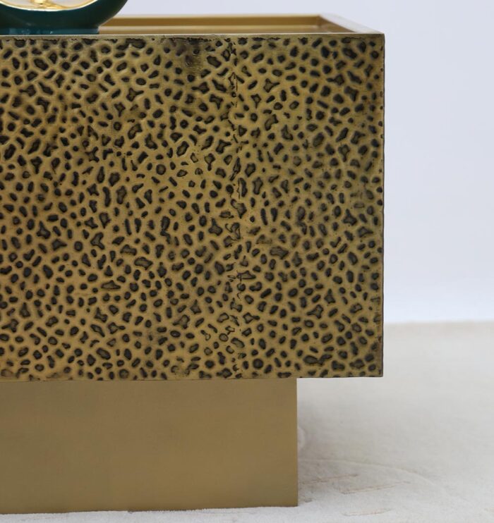 Side angle of square iron side table with textured golden antique design