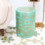 Round modern side table with turquoise dot pattern and golden iron base placed beside a couch