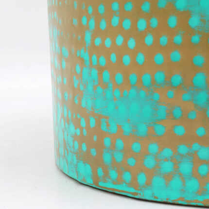 Close-up of round coffee table showing turquoise dot pattern and golden iron base details