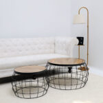 Home décor industrial nesting side tables with round solid wood tops, used together to create a chic, layered accent look in a modern living room.