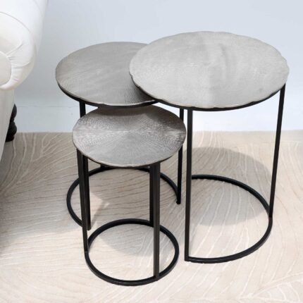 Top angled view of modern round coffee table showing aluminium top texture and black iron legs