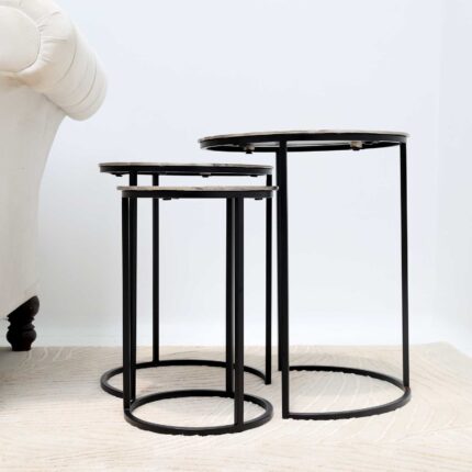 Side view of modern round coffee table with aluminium top and black iron legs – minimalist industrial design