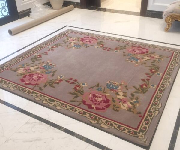 Full view of a modern organic shape abstract rug with bold black contour lines, contrasting against a white minimalist sectional sofa and tiled floor.