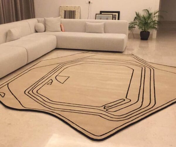 Modern abstract rug with a striking black contour line design and an asymmetrical, organic shape in a minimalist living room.