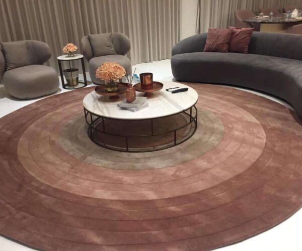 Luxury textured floral rug in natural beige with raised pink and blue cherry blossom motifs, styled in an elegant living room setting.