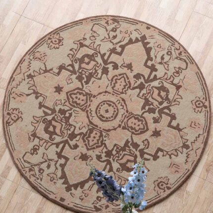 An Artisanal Round Wool Rug with a brown and beige vintage medallion pattern on a light wooden floor.
