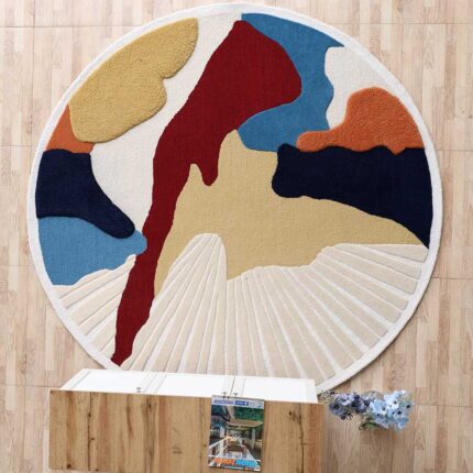 An Abstract Round Area Rug with bold red, blue, and yellow fluid shapes and a hand-carved radial textured section.