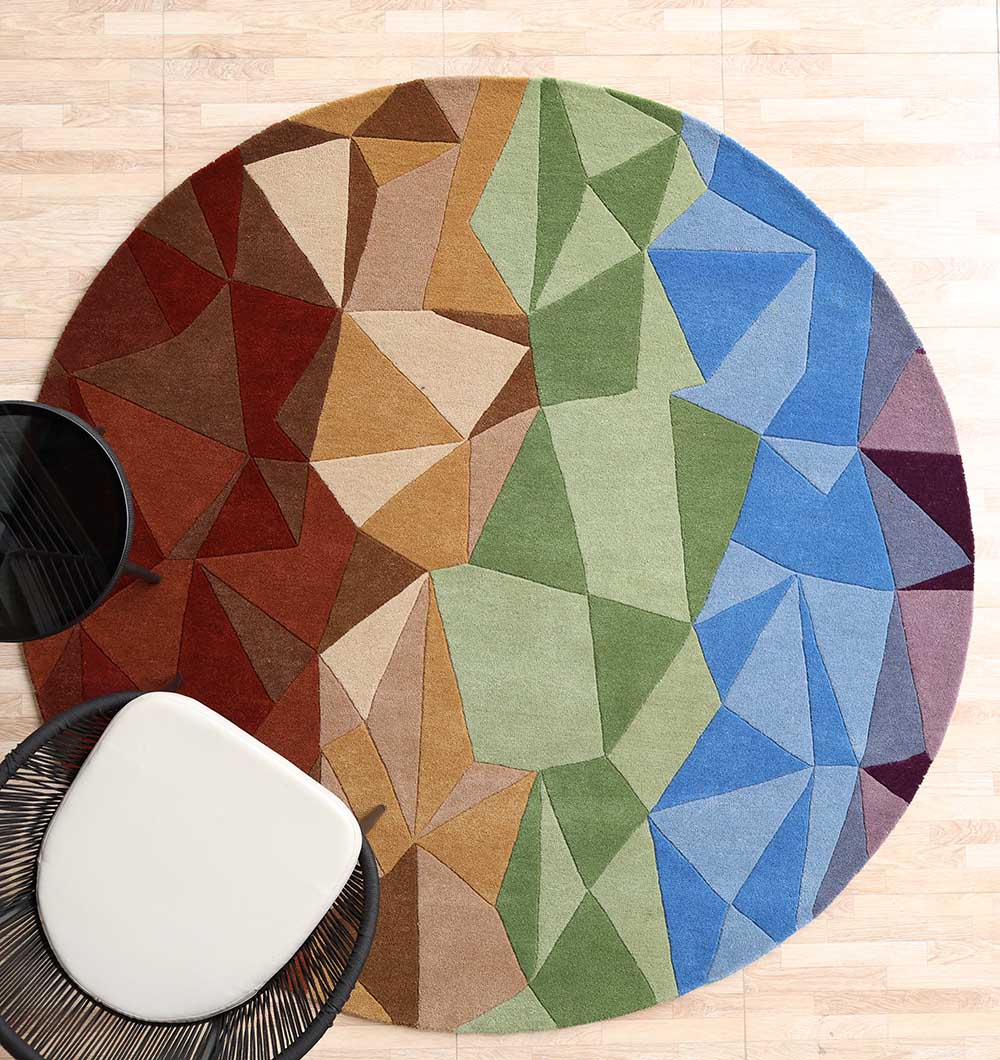 Modern Geometric Shaped Rug - HTWV 184 A Modern Geometric Round Rug featuring a colorful mosaic of blue, green, and orange triangles on a light wooden floor.