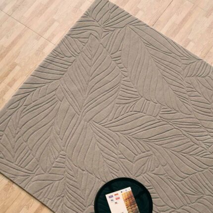 A Grey Color Area Rug with a monochromatic hand-carved leaf pattern and deep sculptural ridges.