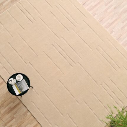 A large rectangular Beige Color Area Rug featuring a minimalist hand-carved pattern of clean horizontal lines.