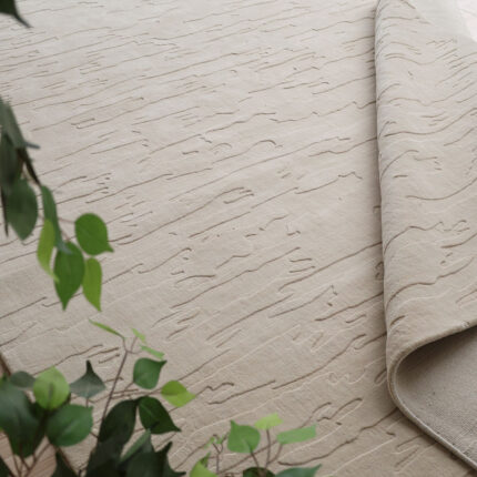 A large Neutral Textured Rug in beige featuring a subtle, organic hand-carved high-low textural pattern across the surface.