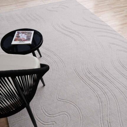 A rectangular Lt Grey Area Rug featuring organic, hand-carved wavy lines and a deep sculptural texture.