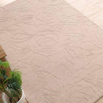 A premium luxury carpet featuring a handmade beige rectangle rug with a deep, hand-carved architectural texture.