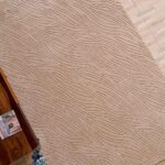 A premium example of bedroom carpets featuring a handmade beige rectangle rug with a deep, hand-carved architectural texture.