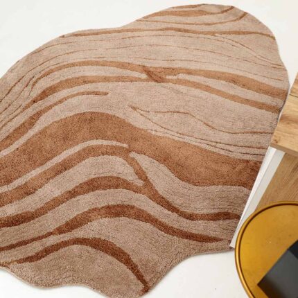A uniquely shaped shaggy rug, a perfect example of home decor Dubai, featuring organic edges and a beige and brown fiber blend.