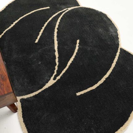 A glamorous example of living room carpets featuring a black and gold shaped shaggy rug with an organic silhouette.